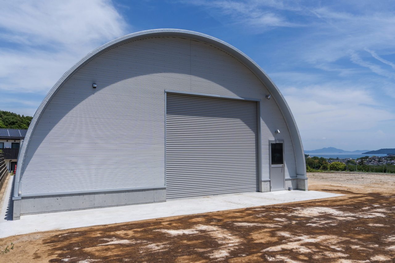 重機・資材保管に最適なスチールアーチ倉庫｜短工期・低コストの施工事例